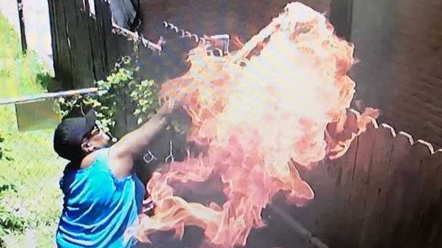 Woman caught on camera throwing fabric engulfed in flames into home 