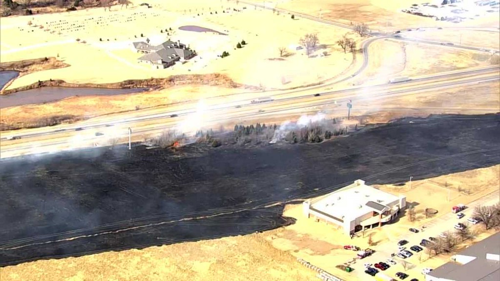 Crews are battling a wildfire near a church in southwest Oklahoma City after a car caught fire on a nearby highway.